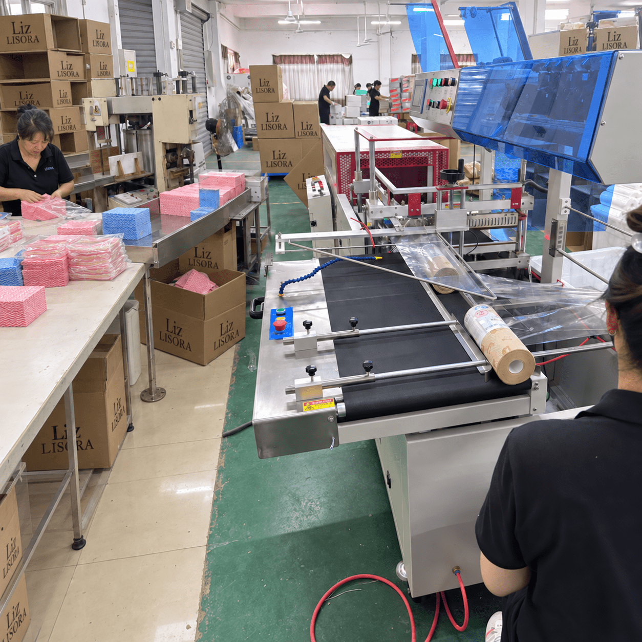 工厂车间内工人操作无纺布制品生产设备