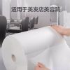 美发店内，双手沿断点撕取白色压纹一次性无纺布卷巾，背景为理发椅，上方标注“适用于美发店美容院”。