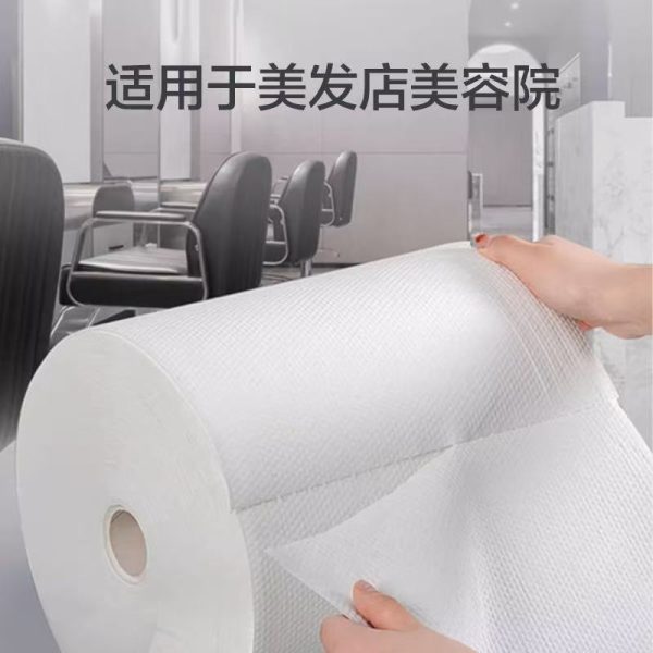 美发店内，双手沿断点撕取白色压纹一次性无纺布卷巾，背景为理发椅，上方标注“适用于美发店美容院”。